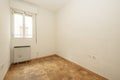 Empty room with gotelet white painted walls, white aluminum windows with electric heat accumulator below and oak parquet slatted