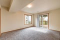 Empty room with gray carpet white walls wood trim sliding glass door to deck with stairs leading to backyard