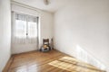 empty room of a house with a floor of beautiful pine driftwood flooring with a window with white curtains and some old objects in Royalty Free Stock Photo