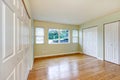 Empty room interior with hardwood floor and three closets.