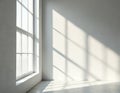 Empty room with large window casting geometric shadow patterns on white wall and concrete floor. Bright daylight illuminates Royalty Free Stock Photo