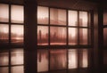An empty room with large windows showing a city skyline at dusk, with a red hue and digital glitch effects.