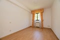 Empty room with oak hardwood floor, white painted walls and matching