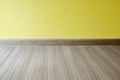 Empty room with oak wood laminate flooring and newly painted yellow wall in background Royalty Free Stock Photo