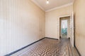 Empty room in an old house that looks like a time capsule with hydraulic tiled floors and wallpapered walls