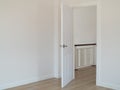 Empty room with open door and white interior wall background.