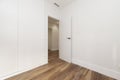 Empty room with open white wooden door, ducted air conditione