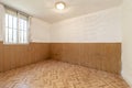 Empty room with parquet-like sintasol floor and walls covered