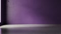Empty room with purple wall and concrete floor illuminated by dramatic light and shadow Royalty Free Stock Photo