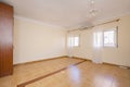 Empty room with stoneware floor, air conditioner between two aluminum windows with white curtains Royalty Free Stock Photo