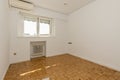 Empty room with tilt-and-turn windows, air conditioner and cast-iron radiators