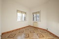 Empty room with two aluminum twin windows with bars and vintage stoneware floors