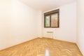 Empty room with varnished French oak parquet floor laid in a herringbone pattern and bright ocher anodized aluminum window