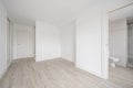 Empty room with white fitted wardrobes, white walls and wood-like ceramic Royalty Free Stock Photo