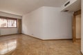 Empty room with white painted walls, French oak parquet wooden floor placed in a herringbone pattern with matching doors and