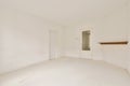 an empty living room with white walls and a door