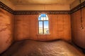 Empty room with a window and sand in the ruined ghost town Kolmanskop, Namibia