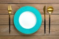 empty round blue plate, fork, knife, spoon on wooden table Top view Flat lay Dishes for breakfast, lunch or dinner Mock up Royalty Free Stock Photo