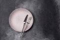 An empty round ceramic plate, knife, and fork as a dining table setting. An empty plate Royalty Free Stock Photo