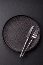 An empty round ceramic plate, knife, and fork as a dining table setting. An empty plate Royalty Free Stock Photo