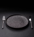 An empty round ceramic plate, knife, and fork as a dining table setting. An empty plate Royalty Free Stock Photo