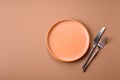 An empty round ceramic plate, knife, and fork as a dining table setting. An empty plate Royalty Free Stock Photo
