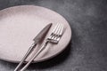 An empty round ceramic plate, knife, and fork as a dining table setting. An empty plate Royalty Free Stock Photo