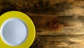 Empty round ceramic plate with yellow edge on rough wooden background or table. Copy space for text. Top down. Flat lay. 16x9 Royalty Free Stock Photo