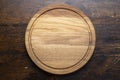 Empty round cutting board on a wooden table. Space for text Royalty Free Stock Photo