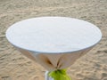 Empty round dining table with white tablecloth and light green bow