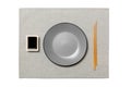 Empty round gray plate with chopsticks for sushi and soy sauce on grey napkin background. Top view with copy space for you design Royalty Free Stock Photo