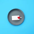 Empty round gray plate and decorative red heart, next to an empty white business card Royalty Free Stock Photo