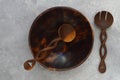 Empty round handcrafted brown wooden plate on stone concrete background, top view