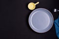 Empty round plate with rehearsal Cloth arranged on the table on a dark moody black background. simple dinner with copy space, top