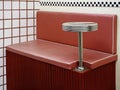 Empty round stainless steel side table fixing on red retro style diner booths. Royalty Free Stock Photo