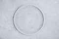 Empty round stone plate on gray concrete background, top view Royalty Free Stock Photo