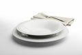 Empty round white plate and bowl with napkin and fork Royalty Free Stock Photo