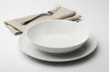 Empty round white plate and bowl with napkin and fork Royalty Free Stock Photo