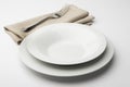 Empty round white plate and bowl with napkin and fork Royalty Free Stock Photo