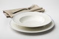 Empty round white plate and bowl with napkin and fork