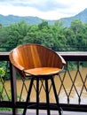 Empty round wooden bar stool made by small wood planks and black steel frame near the outdoor table bar. Royalty Free Stock Photo