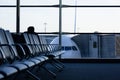Empty row of seats in waiting area at airport with airplane on background Royalty Free Stock Photo