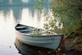 an empty rowboat sits on the shore of a lake