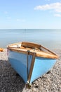 Empty rowing boat on ashingle beach Royalty Free Stock Photo