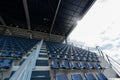 Empty Rows of stadium grandstand seats or stadium seats with sunray on roof and cloud sky, plastic blue and white seats on grand s Royalty Free Stock Photo