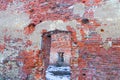 Empty ruined brick house empty door opening weathered old wall view of the courtyard covered with snow Royalty Free Stock Photo