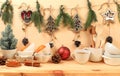 Empty rustic table with a live Christmas tree in a mug, pine cones, cinnamon, kitchen utensils and homemade wooden ornaments. Royalty Free Stock Photo