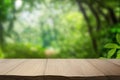 Empty rustic wooden table defocused green lush foliage background product display Generative AI