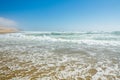 Empty sand beach, ocean waves, and clear blue sky on background Royalty Free Stock Photo