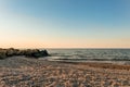 Empty sandy beach in Peresyp resort village. Evening sea landscape. Stacked stone boulders.